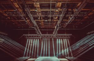 A contemporary indoor stage setup featuring dramatic lighting and intricate architectural patterns.